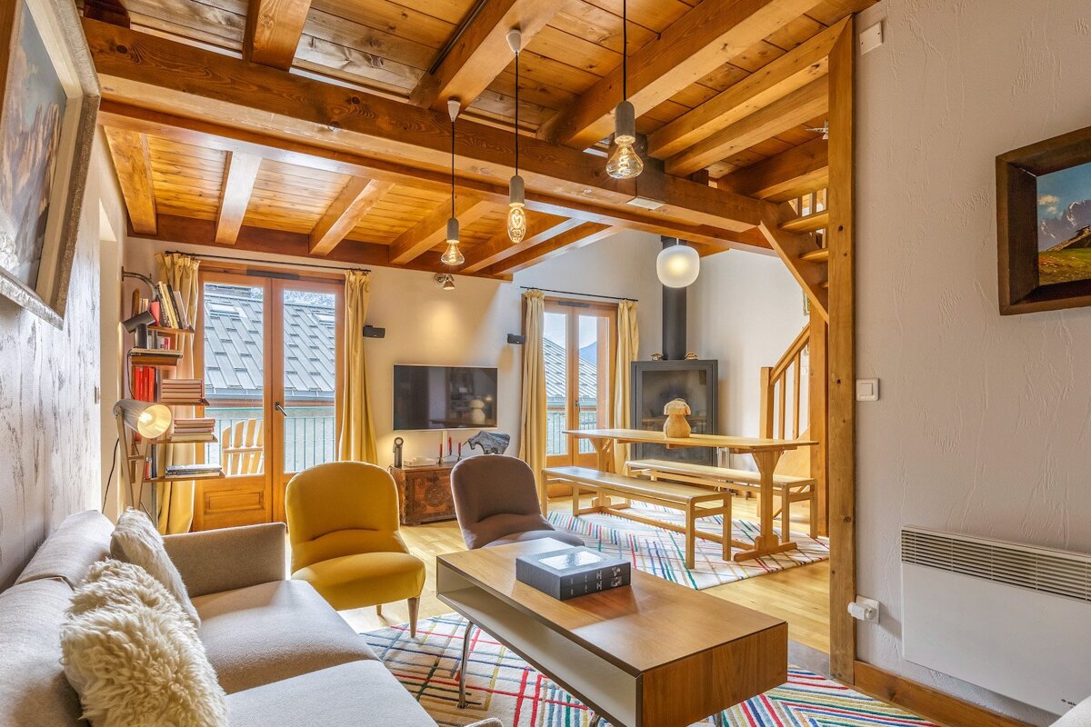 A living room with a couch and chairs and a book on the coffee table