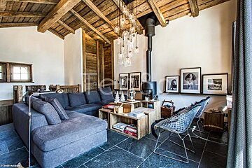 A living room with a couch and chairs and a picture of a woman on the wall