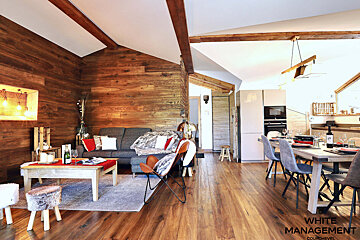 A living room with a couch and a table with a bottle of wine on it