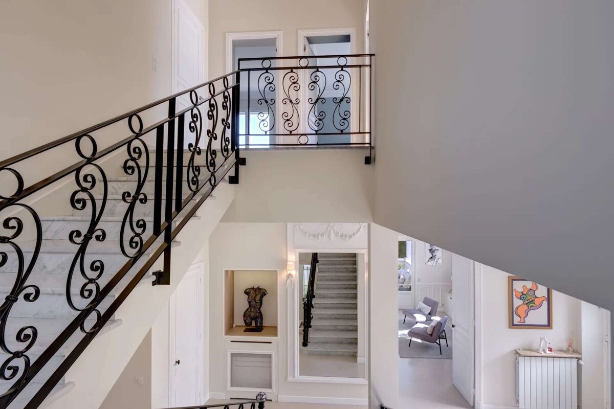A staircase with a wrought iron railing leading up to the second floor