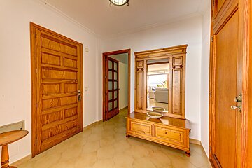 A hallway with a wooden cabinet and a mirror