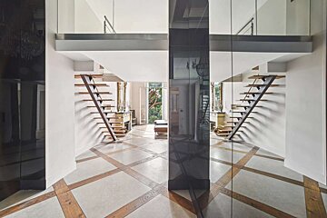 A hallway with a staircase leading up to the second floor