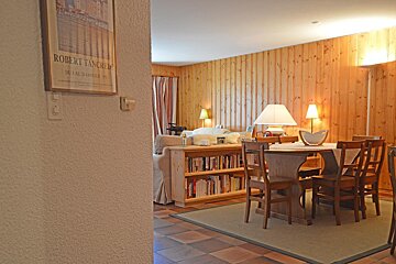 A picture of robert tancrede hangs above a dining room table