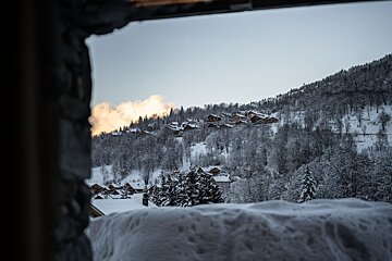 A view of a snowy mountain village from a window