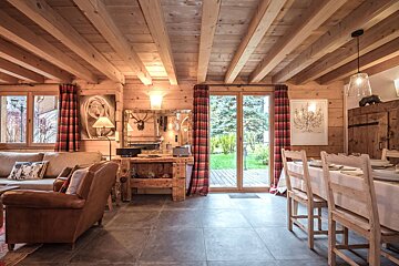 A wooden house with a dining table and chairs