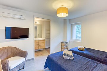 A bedroom with two beds and a flat screen tv