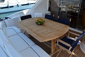 A wooden table with a bowl of fruit on it