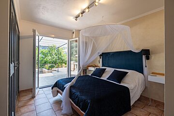 A bedroom with a canopy bed and a balcony