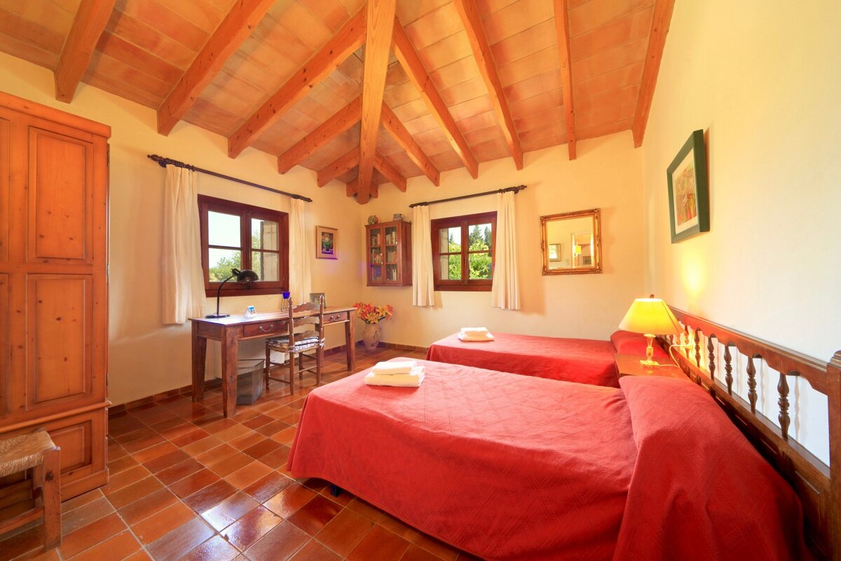 A bedroom with two beds a desk and a mirror