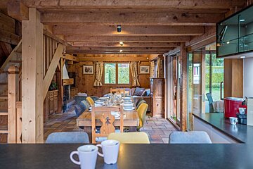 A wooden house with a dining table and chairs