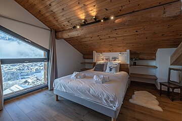 A bedroom with a large bed and a large window