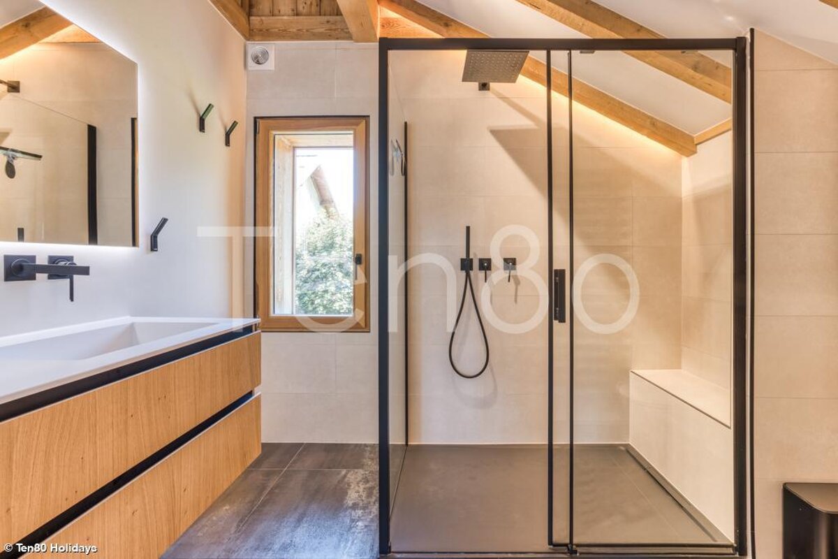 A bathroom with a sliding glass shower door and a sink