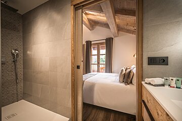 A bathroom with a walk in shower and a sink