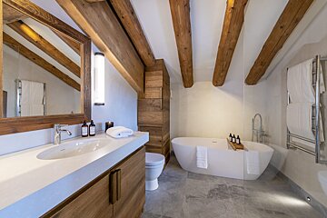 A bathroom with wooden beams and a bathtub
