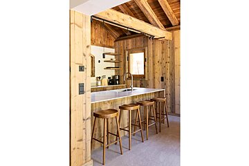 A kitchen with wooden stools and a sink