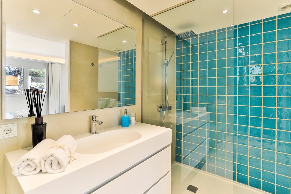 A bathroom with blue tiles and a sink