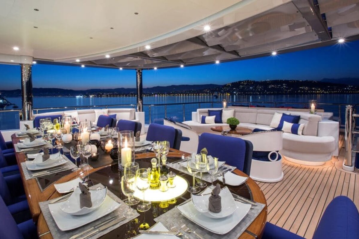 A dining area on a boat with a view of the ocean