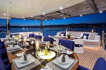 A dining area on a boat with a view of the ocean