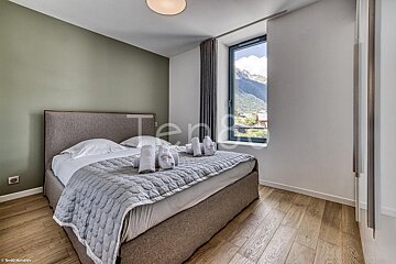 A bedroom with a large bed and a window that says tente