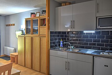 A small kitchen with a sink and a microwave