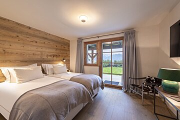A bedroom with two beds and a sliding glass door