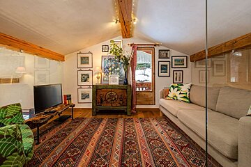 A living room with a couch a rug and a television