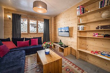 A living room with a blue couch and a flat screen tv