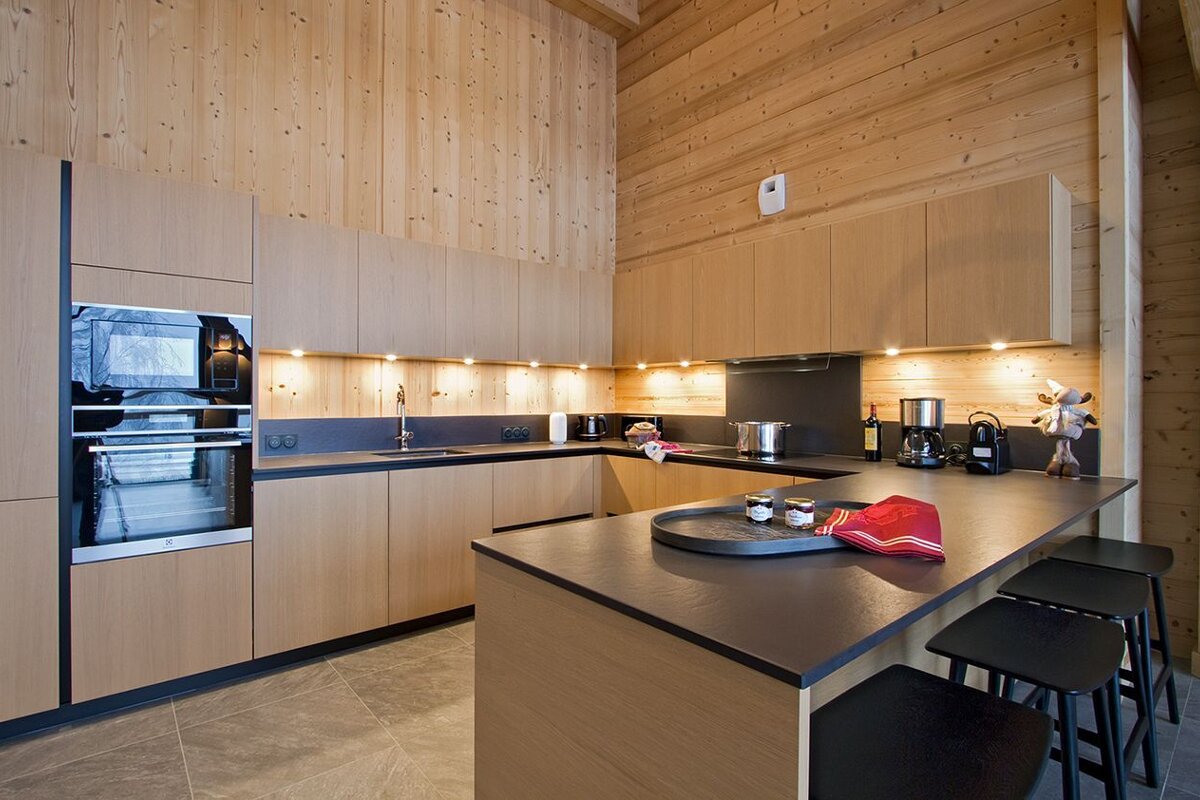 A kitchen with wooden cabinets and black counter tops