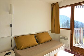 A bedroom with a couch and two yellow pillows