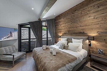 A bedroom with a large bed and a picture of a skier on the wall