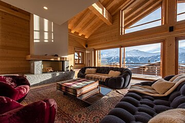 A living room with a fireplace and a view of the mountains