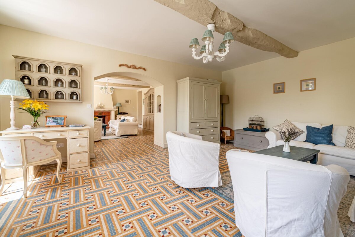 A living room with a couch and chairs and a desk