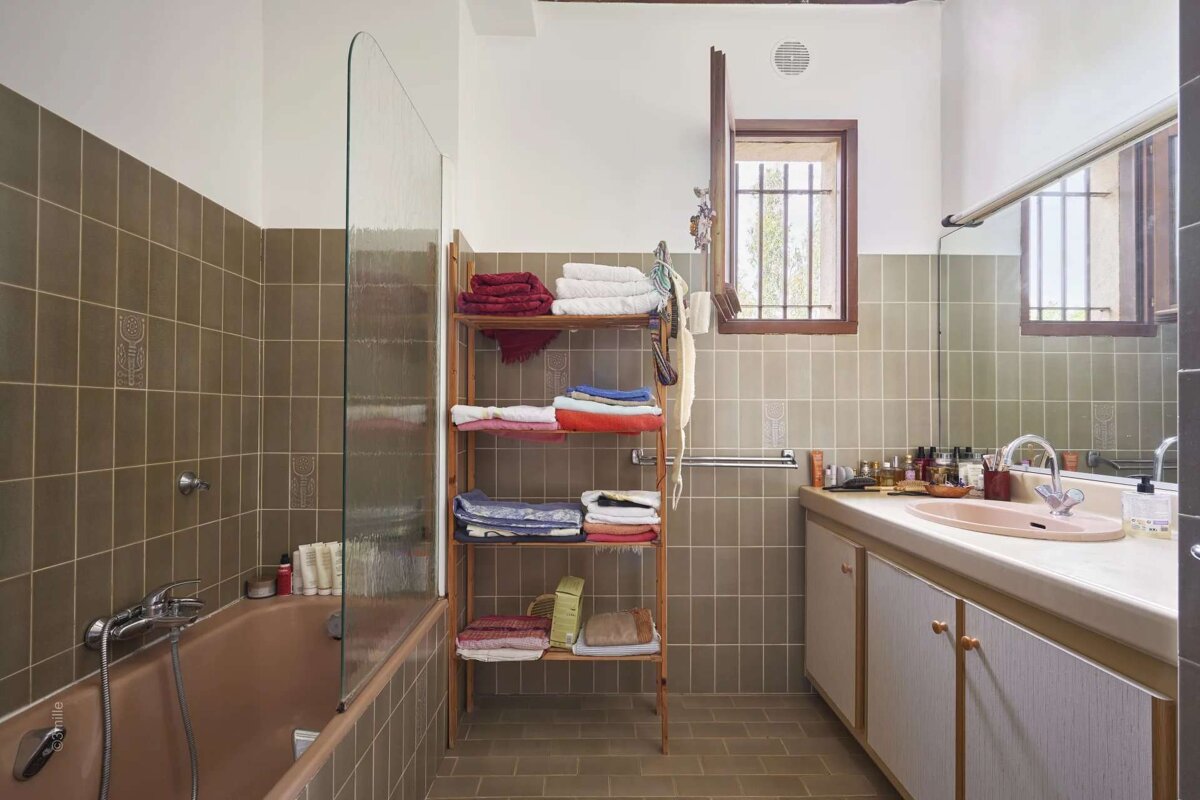 A bathroom with a bathtub and a shelf full of towels