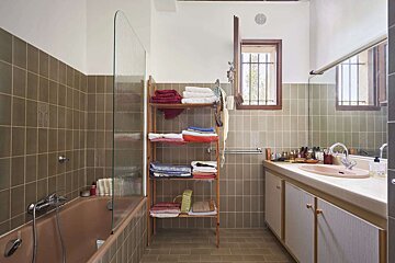 A bathroom with a bathtub and a shelf full of towels