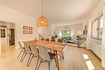 A dining room with a wooden table and chairs
