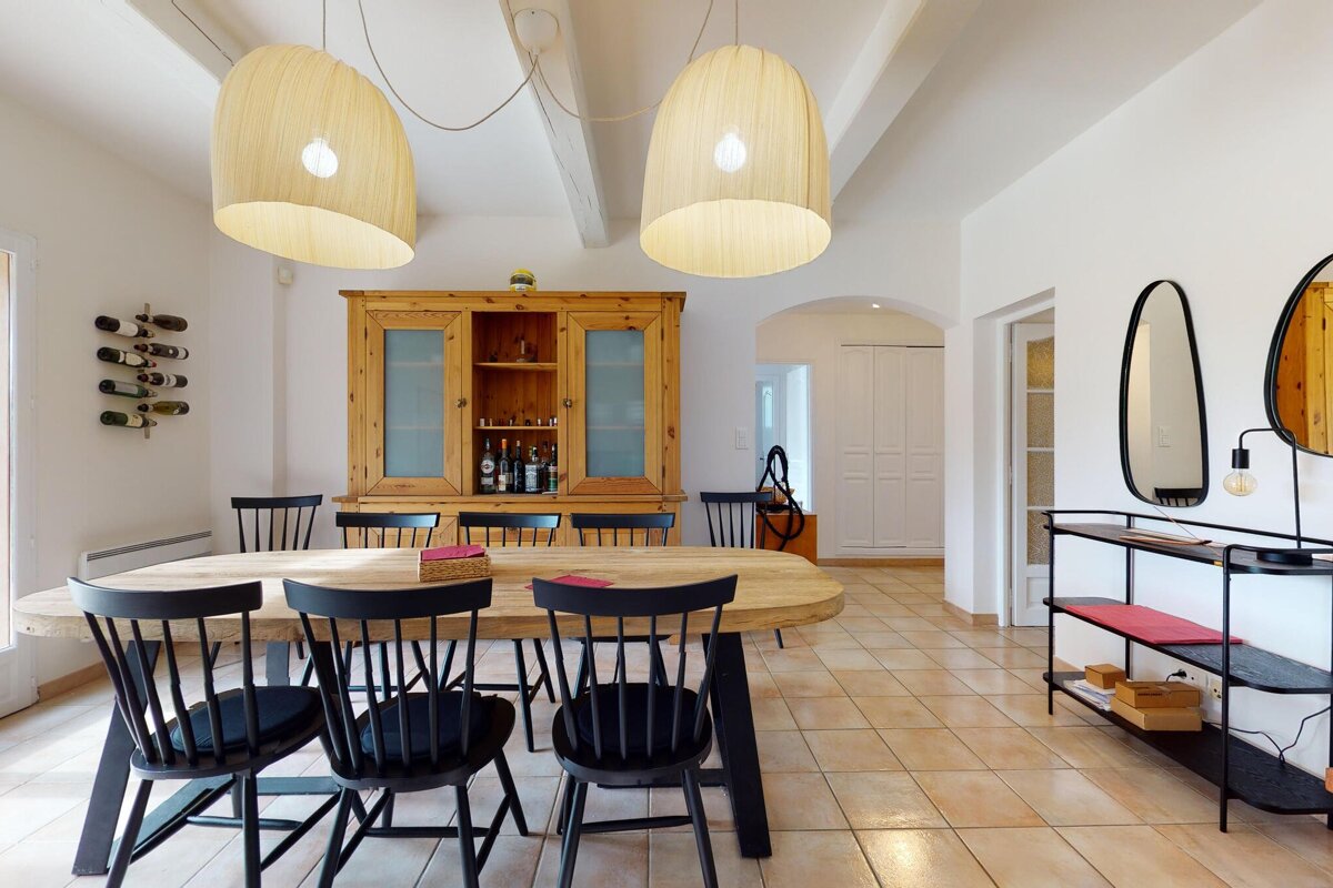 A dining room with a wooden table and black chairs