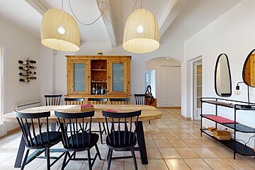 A dining room with a wooden table and black chairs