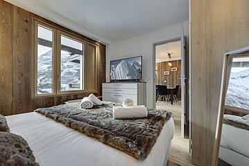 A bedroom with a bed and a flat screen tv