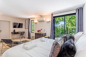 A bedroom with a large bed and a sliding glass door
