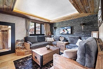 A living room with a couch and a tv on the wall