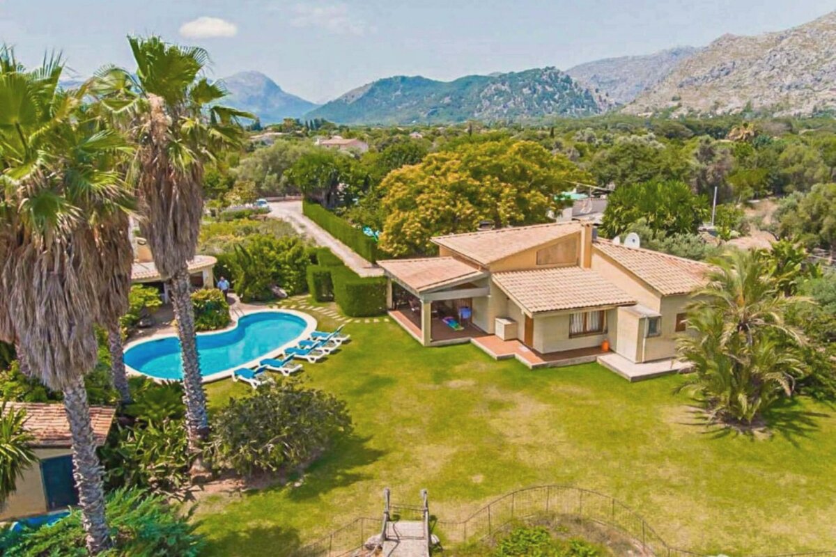 An aerial view of a house with a pool and palm trees