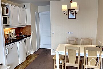 A kitchen with a table and chairs and a coffee maker