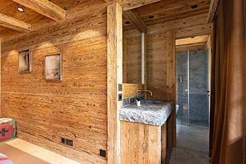 A bathroom with wooden walls and a sink