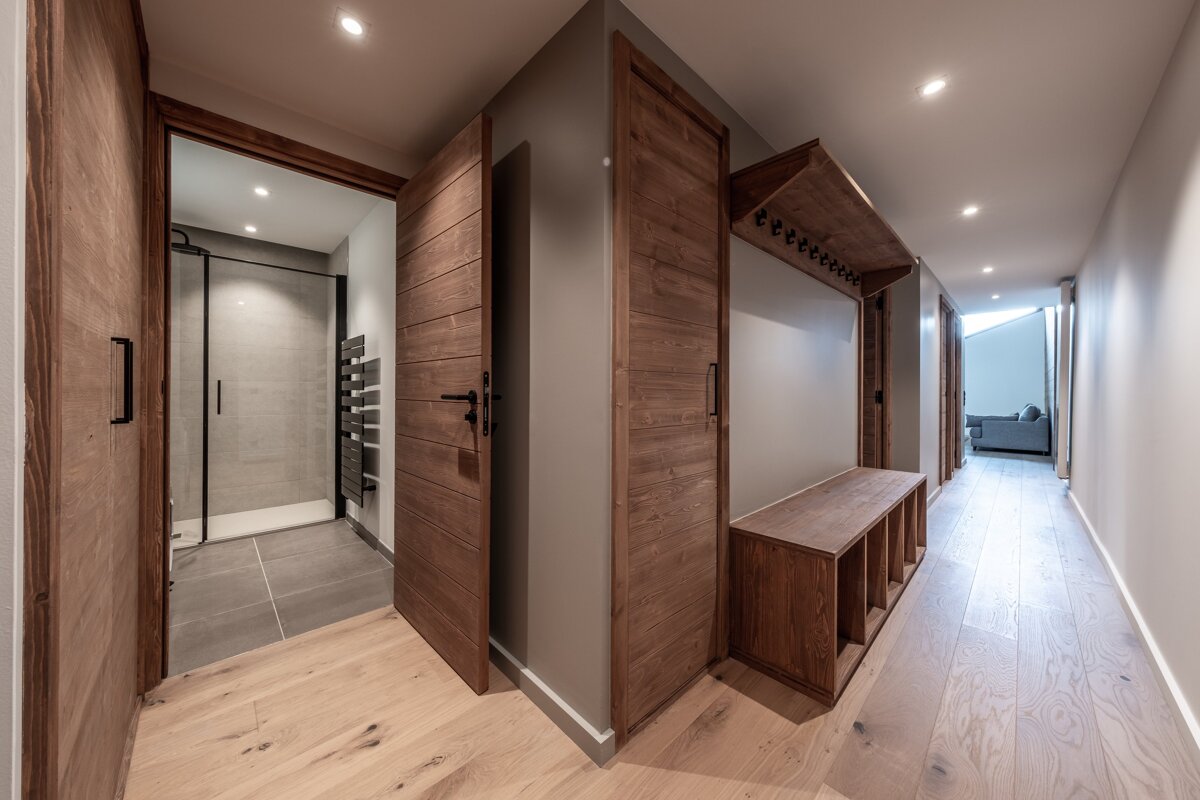 A hallway with wooden doors leading to a bathroom