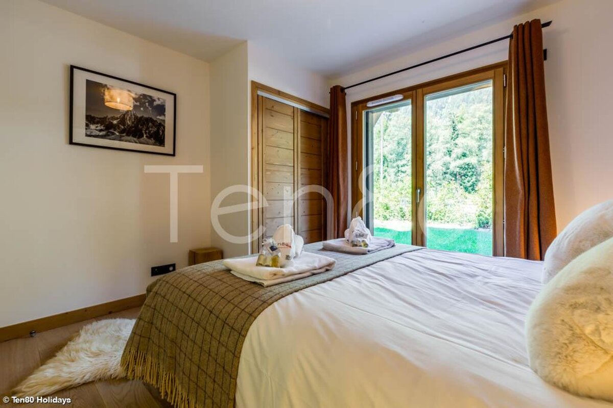 A bedroom with a bed and a picture on the wall that says ten80 holidays