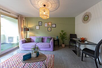 A living room with a purple couch and a table