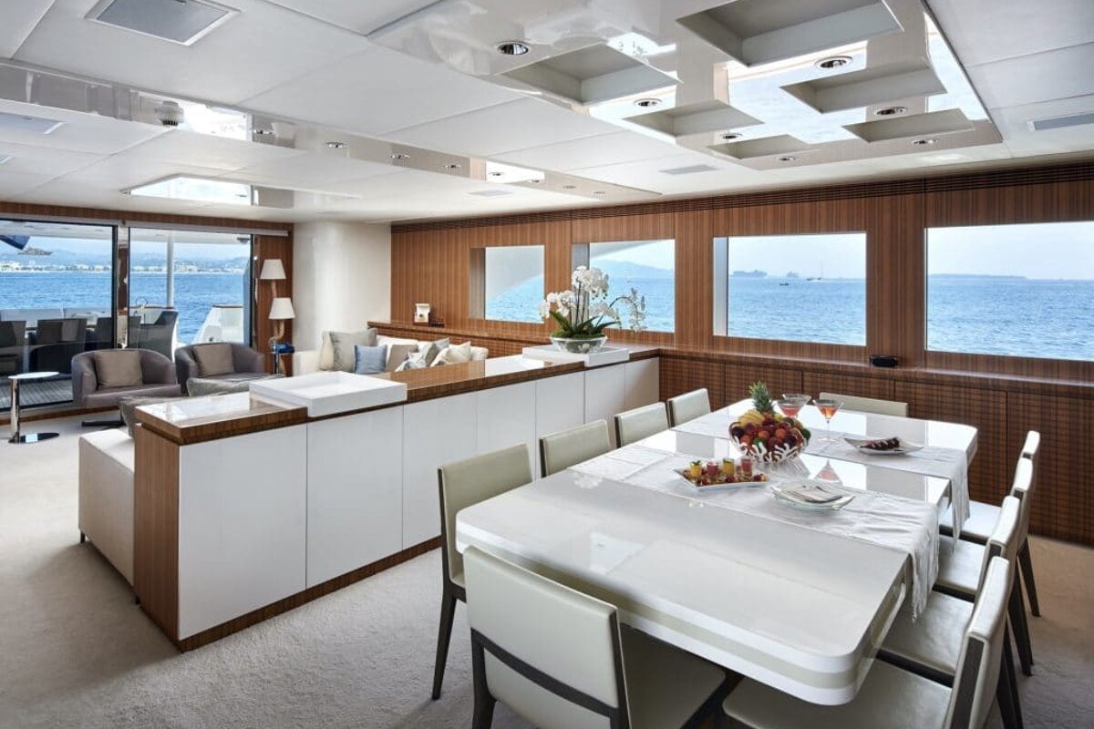 A dining room table with a bowl of fruit on it