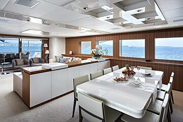 A dining room table with a bowl of fruit on it