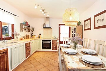 A kitchen with a table and chairs and plates on it