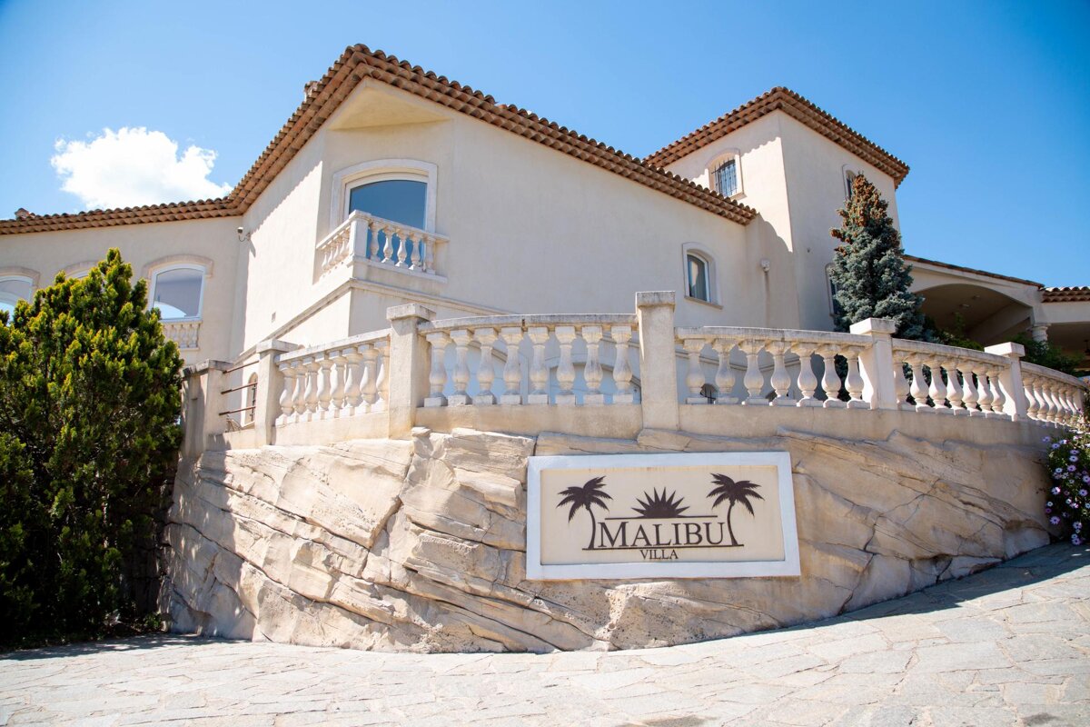 A large white building with a sign that says malibu villa
